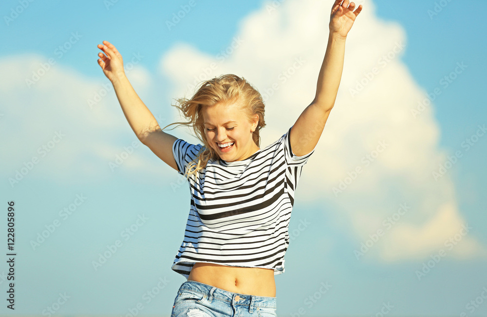Happy young woman on blue sky background