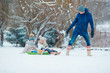 © travnikovstudio - Little girls enjoying sledding in winter day. Father sledding his little adorable daughters. Family vacation on Christmas eve outdoors