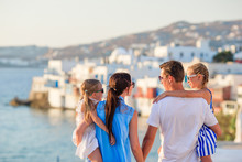 Family Vacation In Europe. Parents And Kids On Little Venice Background On Mykonos Island, In Greece