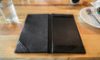 © Mumemories - Black leather tray blank space payment bill on wooden table