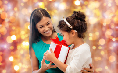 Canvas Print - happy mother and girl with gift box over lights