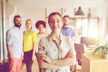 Canvas Print - happy young woman over creative team in office