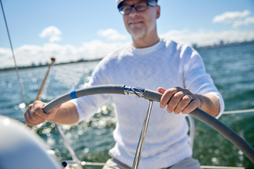 Poster - senior man at helm on boat or yacht sailing in sea