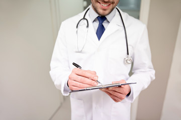 Wall Mural - close up of doctor with clipboard at hospital