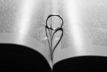 Ring Casting A Heart-shaped Shadow On The Book Page