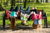 Fototapeta Do akwarium - Młodzież czyta książki w parku na ławce