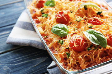 Delicious pasta Al Forno in glass bowl on blue wooden table