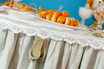 Wall Mural - Strawy slippers hang from a table with sweets