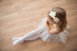© spass - Pretty diligent ballet girl sitting in white tutu at dance studi