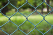 Close-up rusty green fence with blur field background