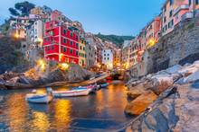Riomaggiore fishing village during evening twilight blue hour, seascape in Five lands, Cinque Terre National Park, Liguria, Italy.