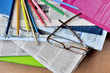 Glasses, color pencils and newspapers on the desktop. Очки, цветные карандаши и газеты на рабочем столе.