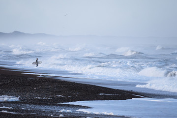 Surfer confronted with stormy waves