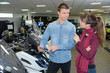 © auremar - Woman in conversation with salesman in scooter showroom