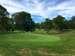 Overlooking the green on a beautiful golf course on a partly cloudy autumn day. Perfect sport activity for young and old.