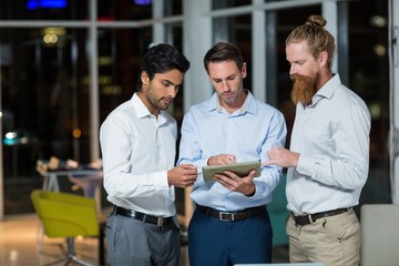 Wall Mural - Businessmen discussing over digital tablet