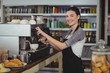 © WavebreakmediaMicro - Portrait of smiling waitress making cup of coffee