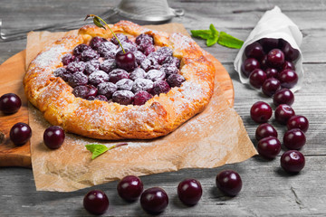 Open pie tart dough with ripe cherries