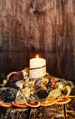 Wall Mural - Christmas home decoration.Candles, ornaments .Dried oranges, Golden ribbon, fir cones on a wooden browm background.