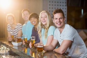 Wall Mural - Group of friends having glass of beer at bar counter