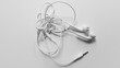 © usssajaeree - Tangled headphone cable on white background isolated.