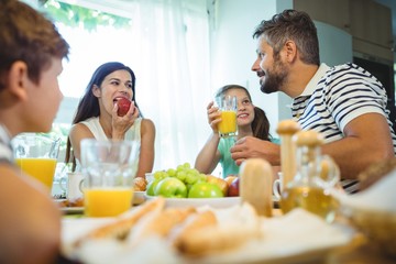 family talking while having breakfast together