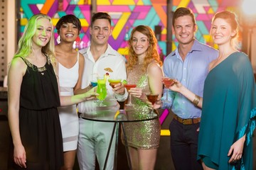 Wall Mural - Group of friends having glass of cocktail in bar