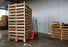 Manual Forklift Pallet With A Stack Of Wooden Crates In A Wareho