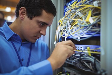 Poster - Technician checking cables in a rack mounted server 