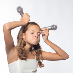 Emotional blonde girl in a white dress singing into a microphone on a white background