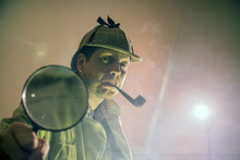 Sherlock Holmes In Studio Etective At Work With Magnifying Glass And Pipe

