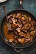 © casanisa - Braised beef stew in a pot. Stewed meat casserole. Top view.