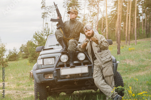 Fotografía armed men near the machine in the forest