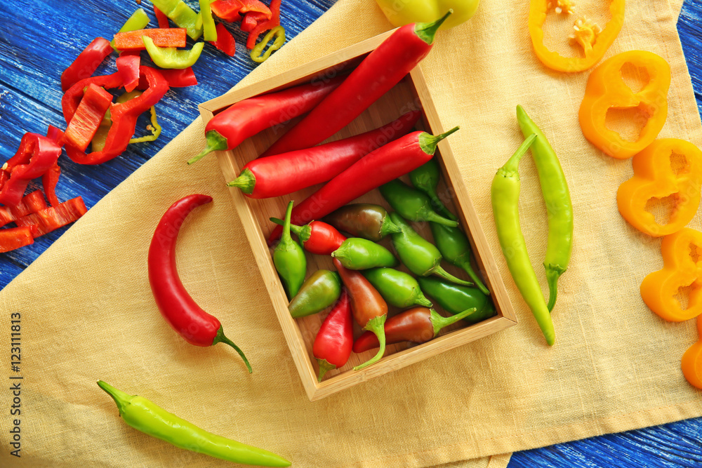 Fresh peppers in wooden box on table