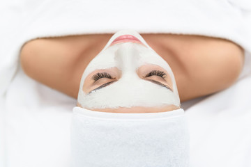 Sensual young woman treating face at beauty salon