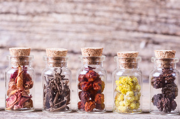 Poster - Herbs in bottles on wooden background