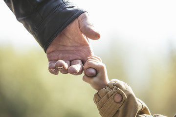 Baby girl warm jacket and cap c grandfather hands in autumn