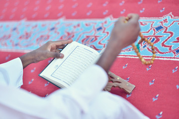 Wall Mural - African Muslim Man Making Traditional Prayer To God While Wearing A Traditional Cap Dishdasha