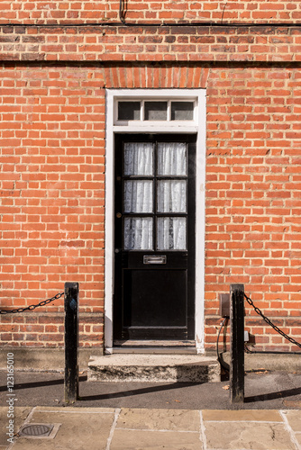 Victorian Black External Wooden Door With Glass Panels On A Red