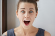 © WHstudio Leushin N - Close-up portrait of surprised Caucasian female in striped sleeveless T-shirt with blue eyes and white skin. Young attractive brunette looking totally shocked, opening mouth in joyful surprise.