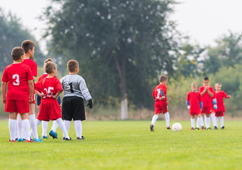 Boys playing football soccer game on sports field