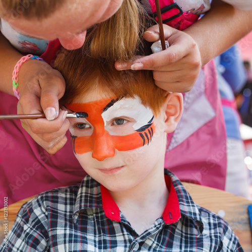 Fotografía Child boy face painting, making tiger eyes process