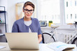 © baranq - Portrait of young businesswoman sitting by desk at her office