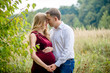 © demchyna - Portrait happy and young pregnant couple hugging in nature