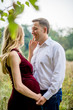 © demchyna - Portrait happy and young pregnant couple hugging in nature