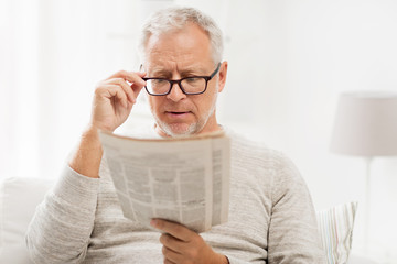 Poster - senior man in glasses reading newspaper at home