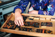 © Connect Images - Senior craftsman reaching for wooden letterpress letters, mid section