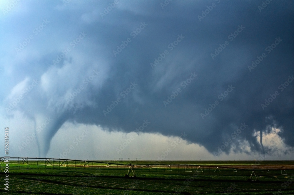 A supercell thunderstorm produces two tornadoes at once in a farm field ...