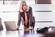 © Connect Images - Determined businesswoman leaning forward on boardroom table