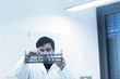 © Connect Images - Scientist examining test tubes in rack